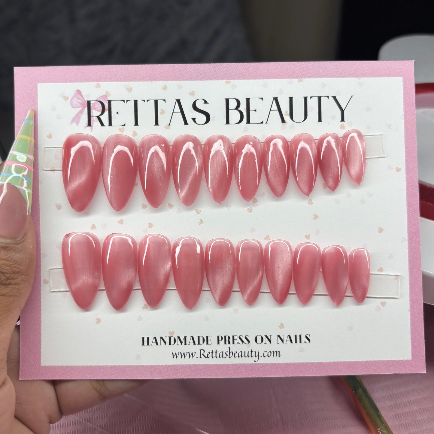Set of pink press-on nails on a card with 'Rettas Beauty' branding.
